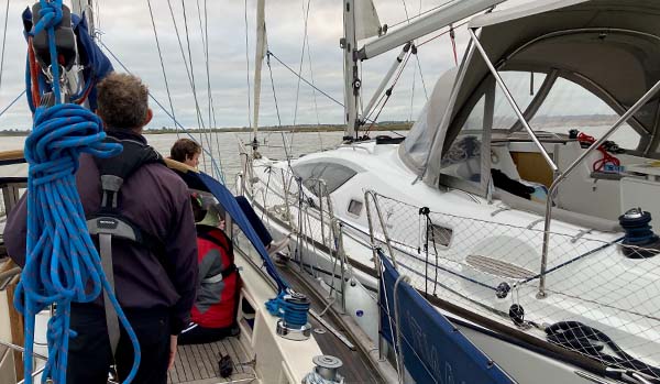 Boat secured alongside and being towed to safety - Credit Mark Lewis, Shearwater Sailing School.