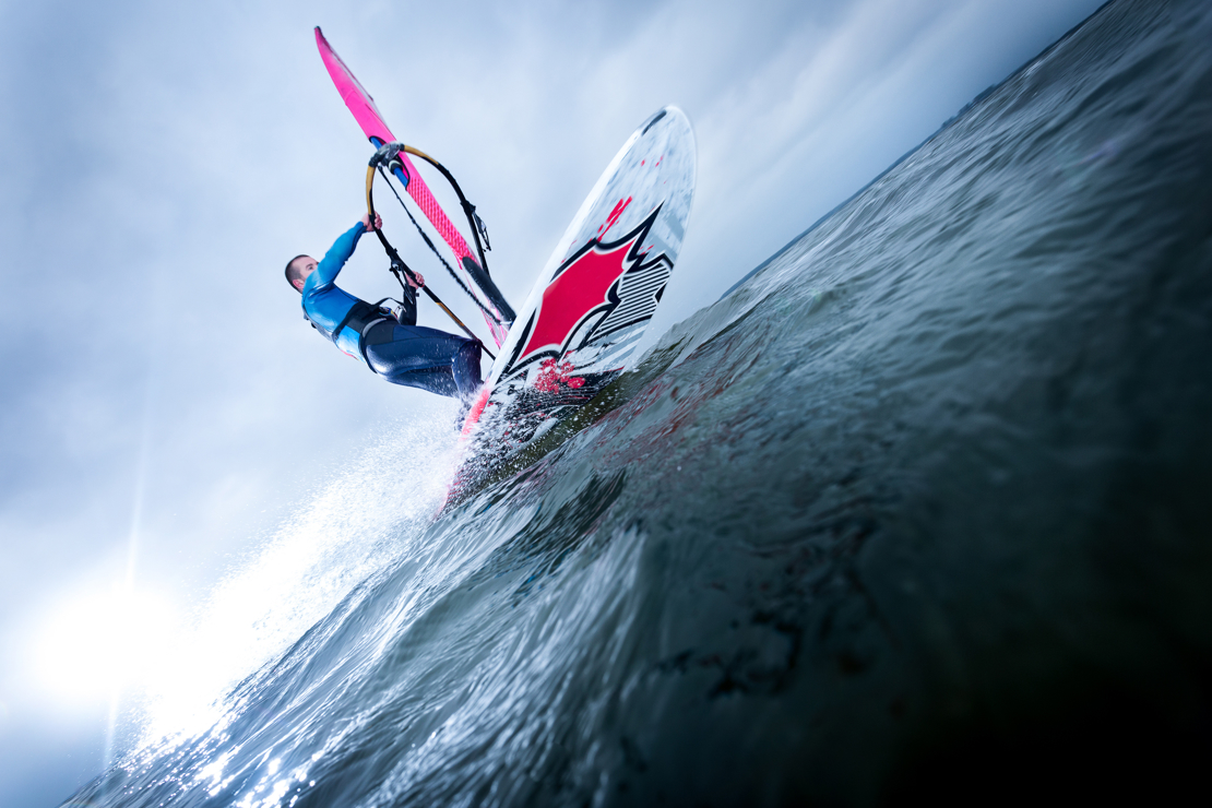 Shot of man windsurfing from the water looking up