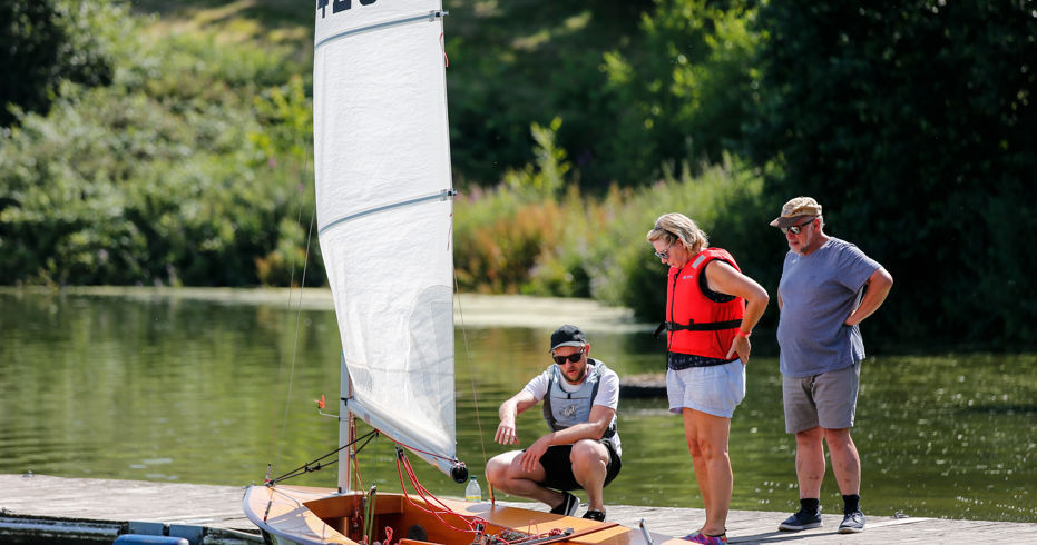 Long shot of a man educating two sailors on boating