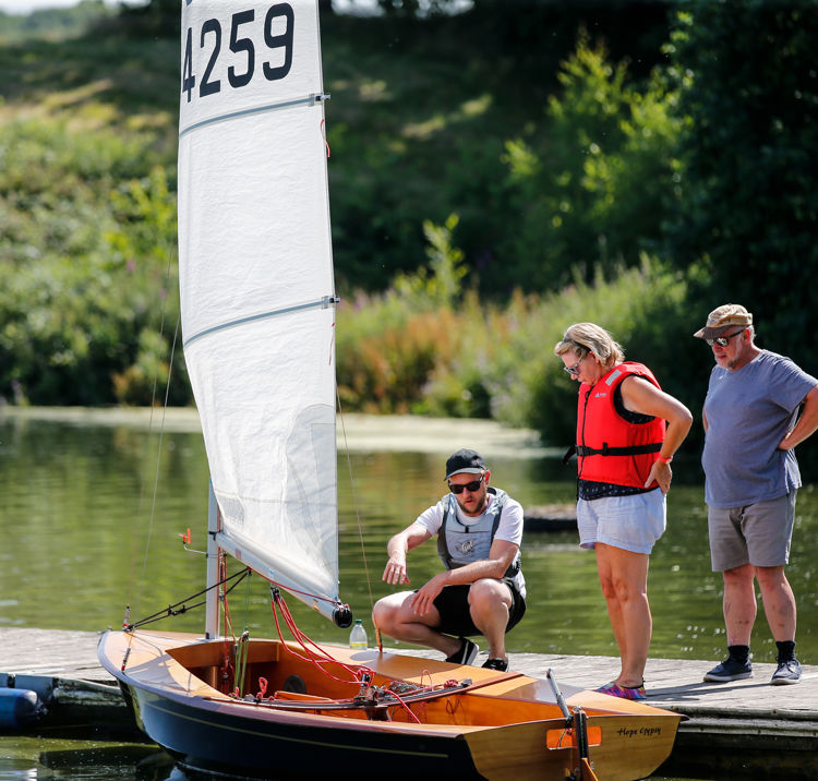 Long shot of a man educating two sailors on boating