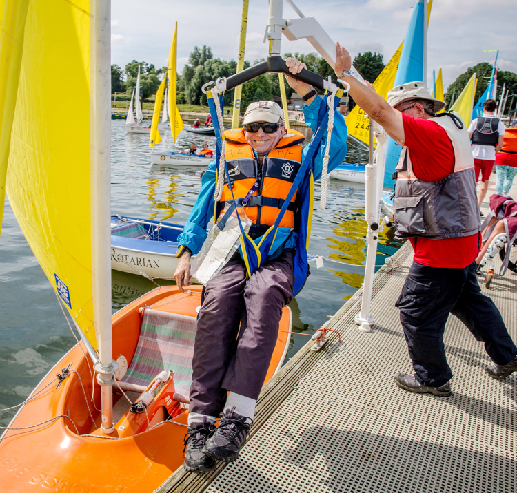 Sailability sailor being lowered into boat