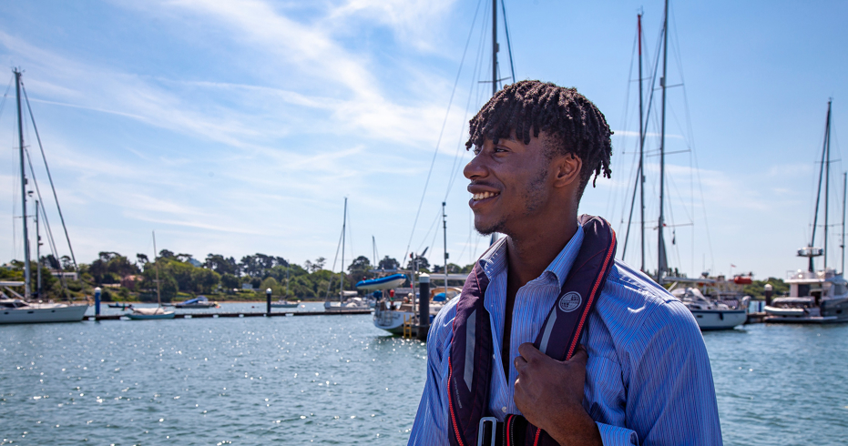 sailor wearing lifejacket looking out at water
