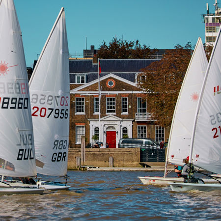 Dinghies sailing in front of a building
