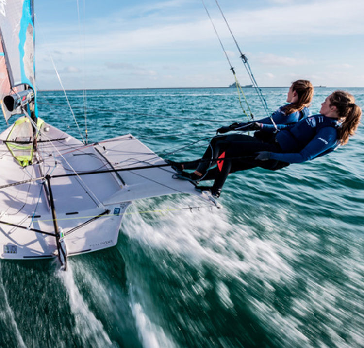 wide shot of racing keelboat in wind
