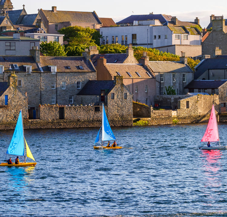 Boats in river alongside town
