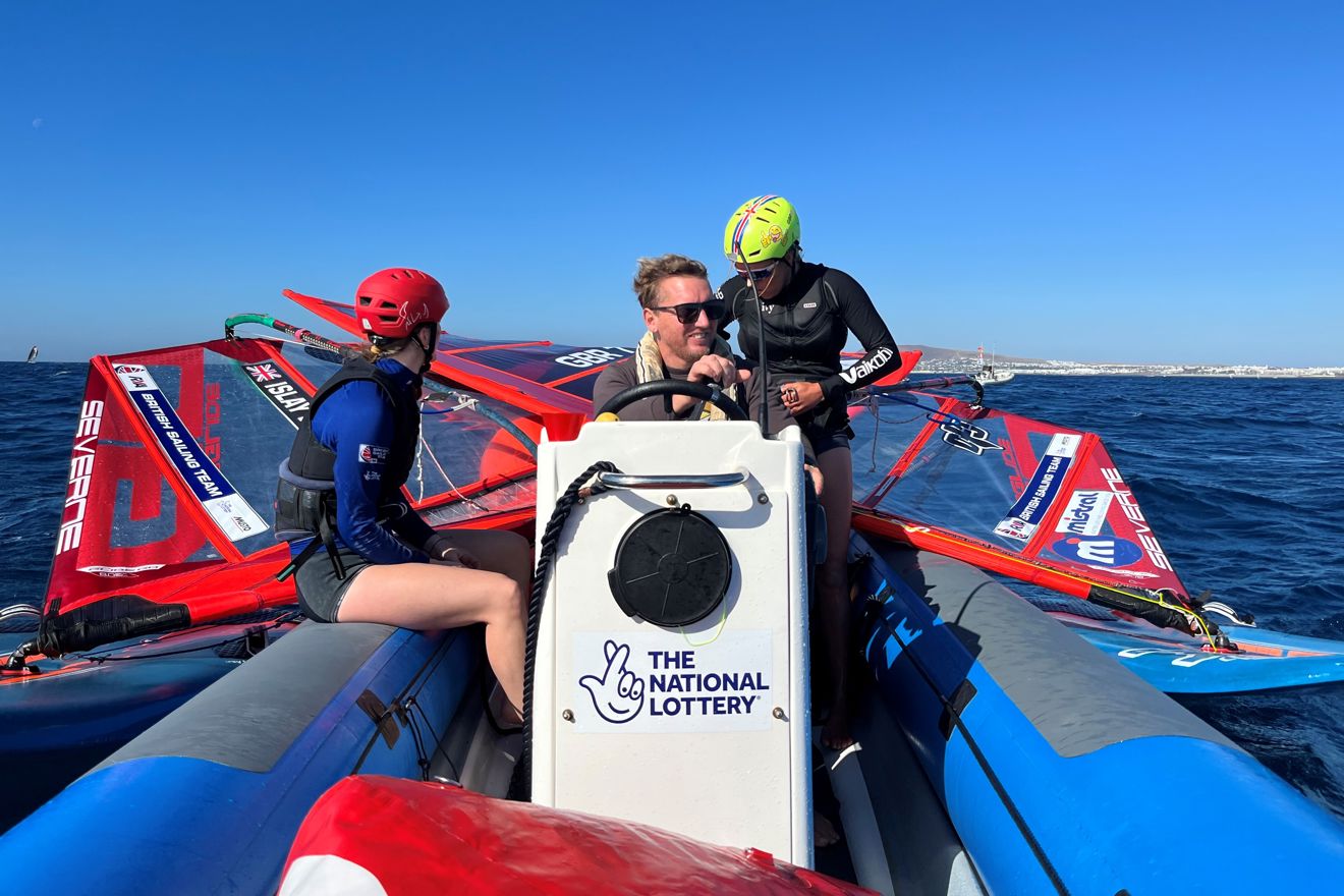 Instructors and pupils on the water during a windsurfing session. 