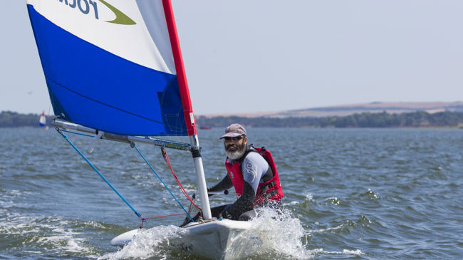 Man sailing a Pico at Rockley Watersports. Rockley logo on sail.July 2018.