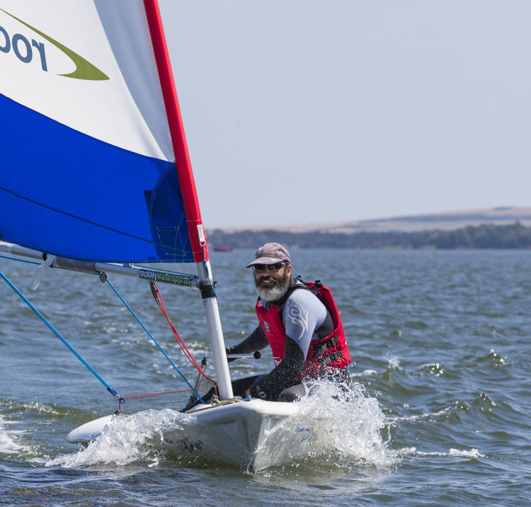 Man sailing a Pico at Rockley Watersports. Rockley logo on sail.July 2018.