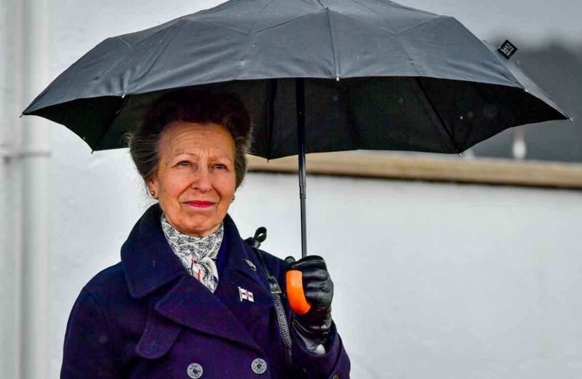 HRH Princess Anne holding an umbrella in the rain