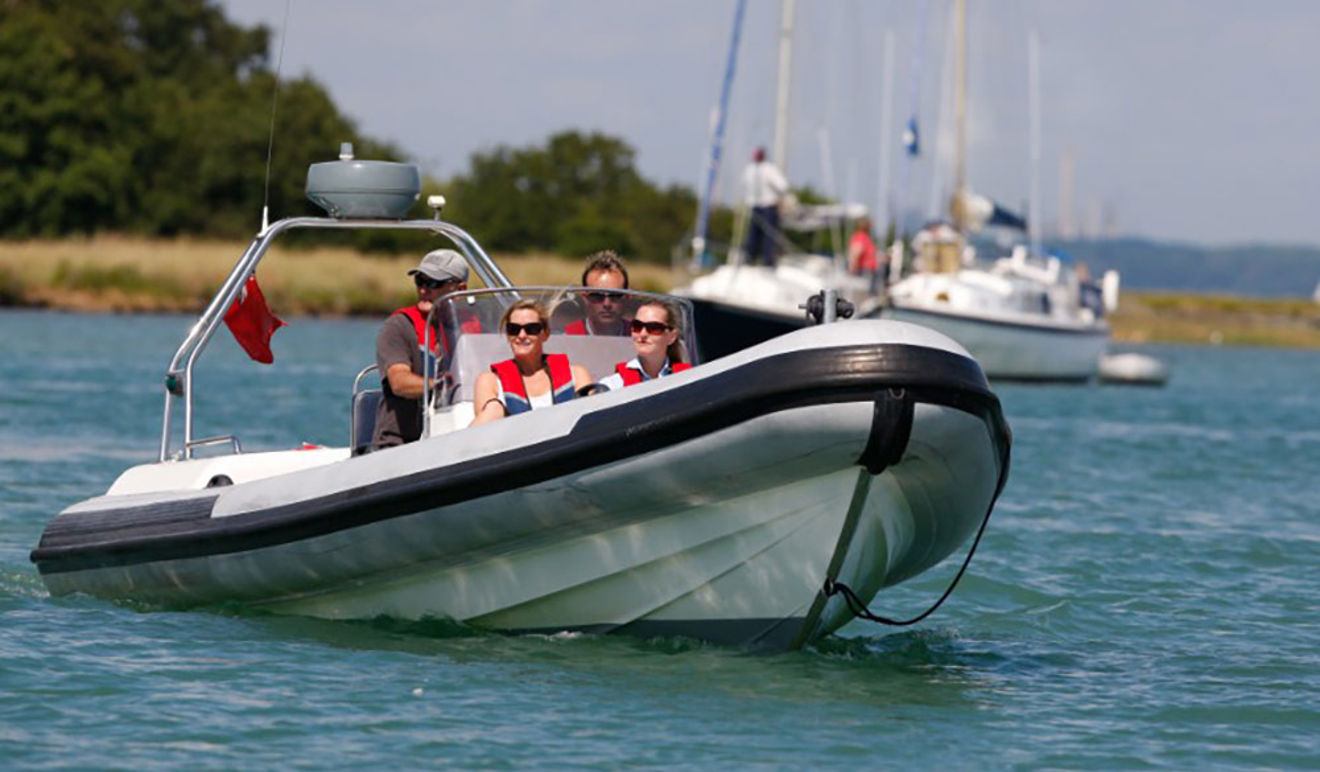 two men and two women on a powerboat rib on the water