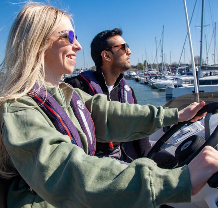 close up of woman and man driving a motor cruiser