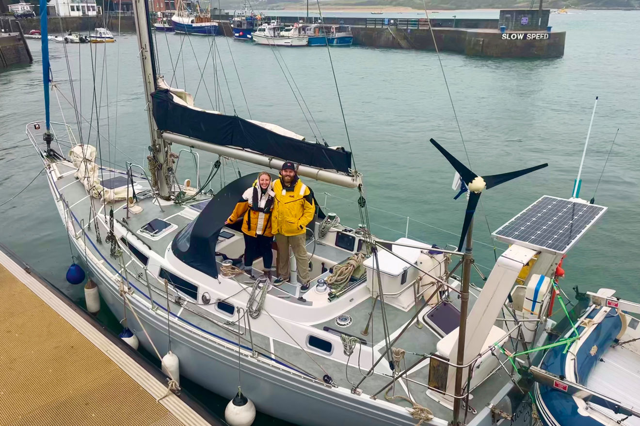 2 people standing on the deck of their yacht
