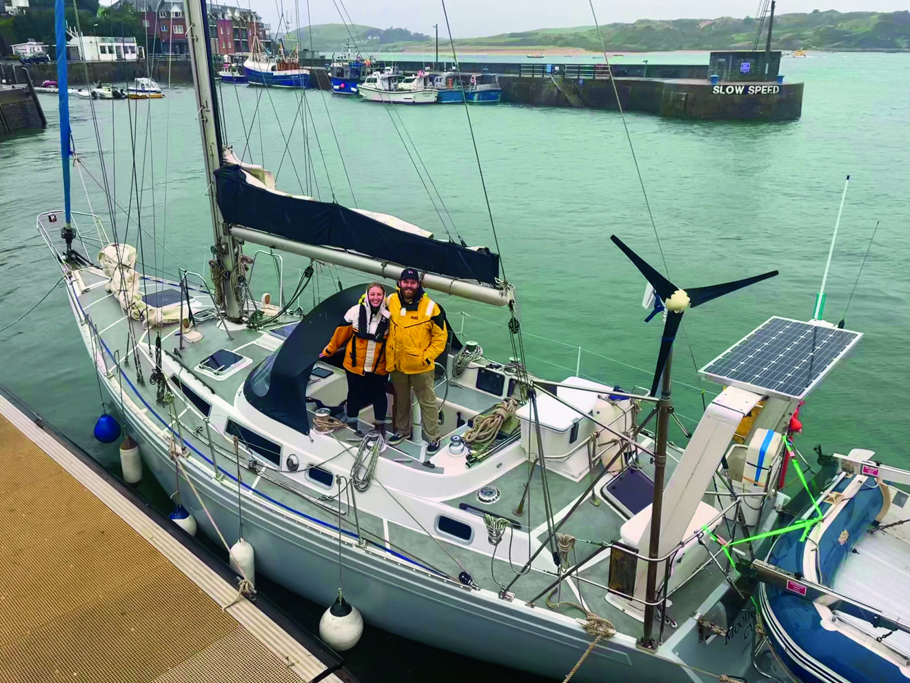2 people standing on the deck of their yacht