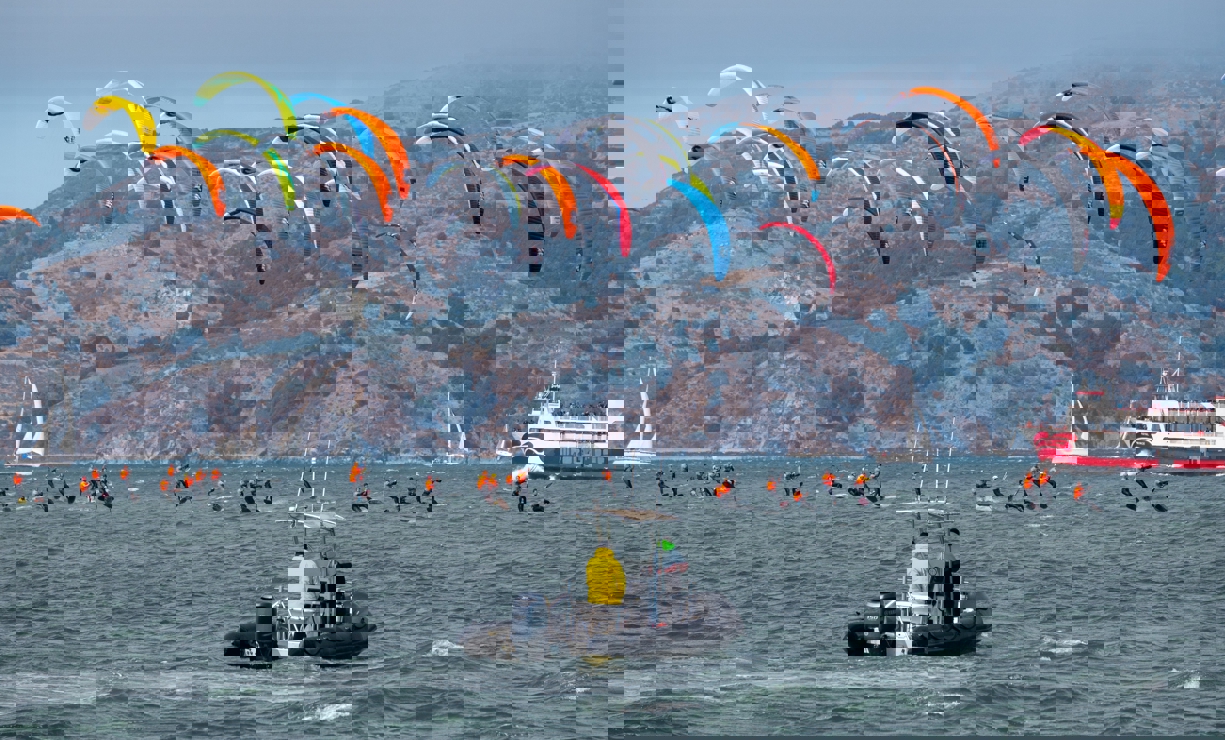 Kite surfers racing with a support rib