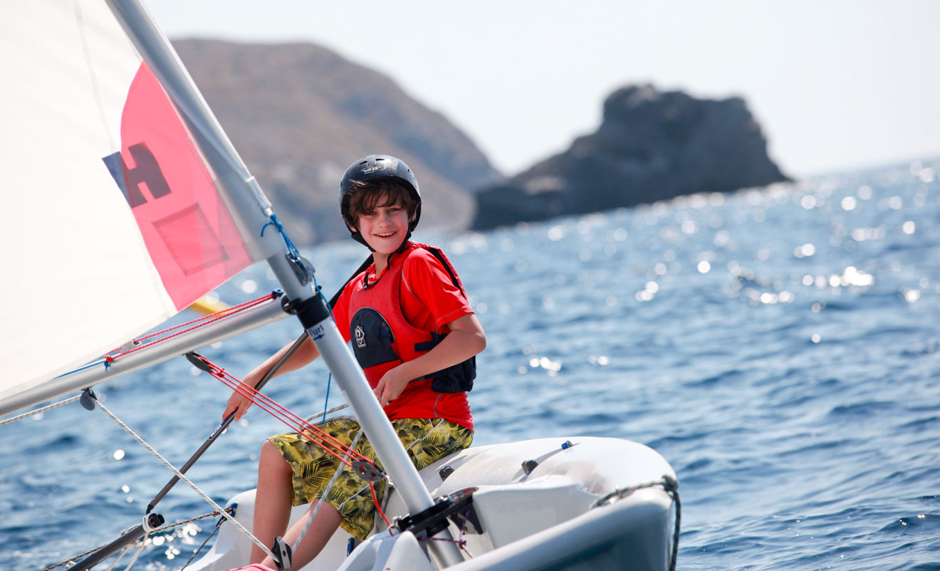 Young boy dinghy sailing as part of a holiday kids club