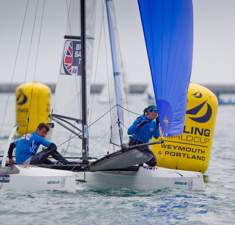 Long shot of two sailors on a multihull with spinnaker