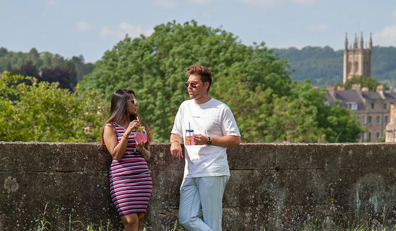 Man and a woman chatting on land enjoying the scenic view