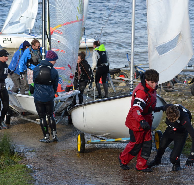 young sailors wheeling their boats up a slipway