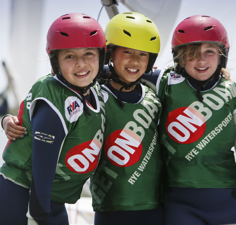 three young girls smiling during an onboard sailing session
