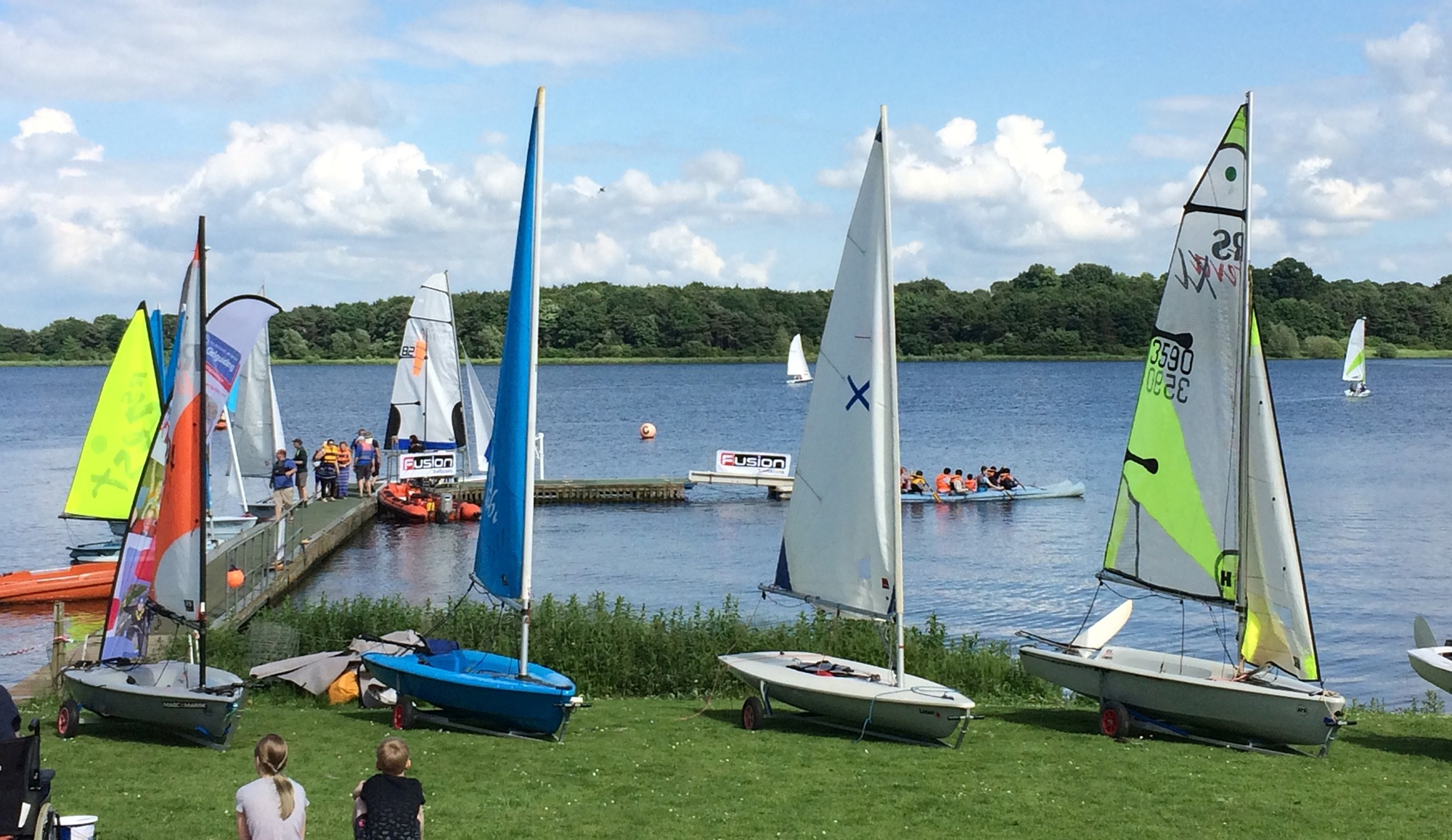 Dinghies lined up on the grass in front of Pitsford reservoir at Northampton Sailing Club