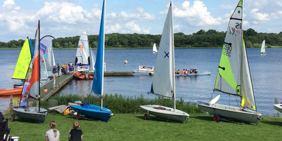 Dinghies lined up on the grass in front of Pitsford reservoir at Northampton Sailing Club