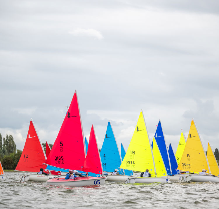 colourful dinghies against a cloudy backdrop