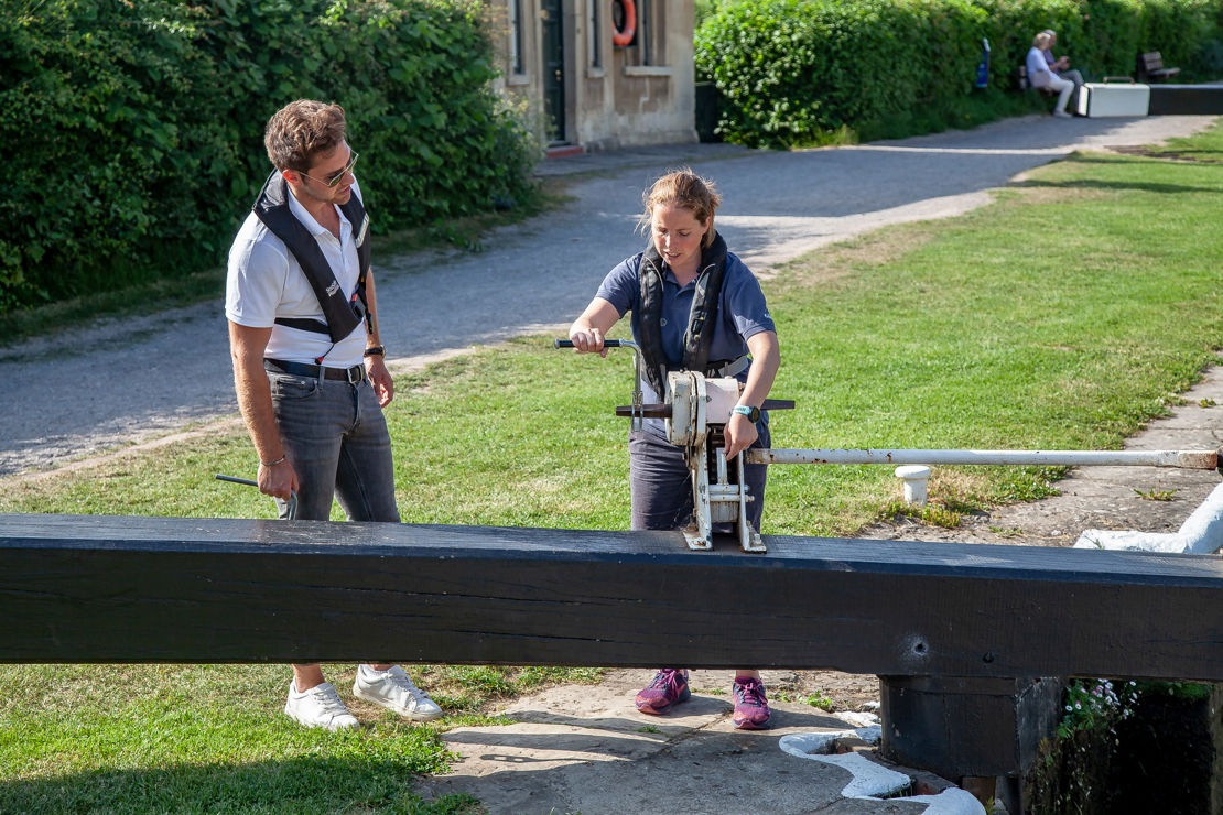 Trainer showing trainee how to operate canal lock