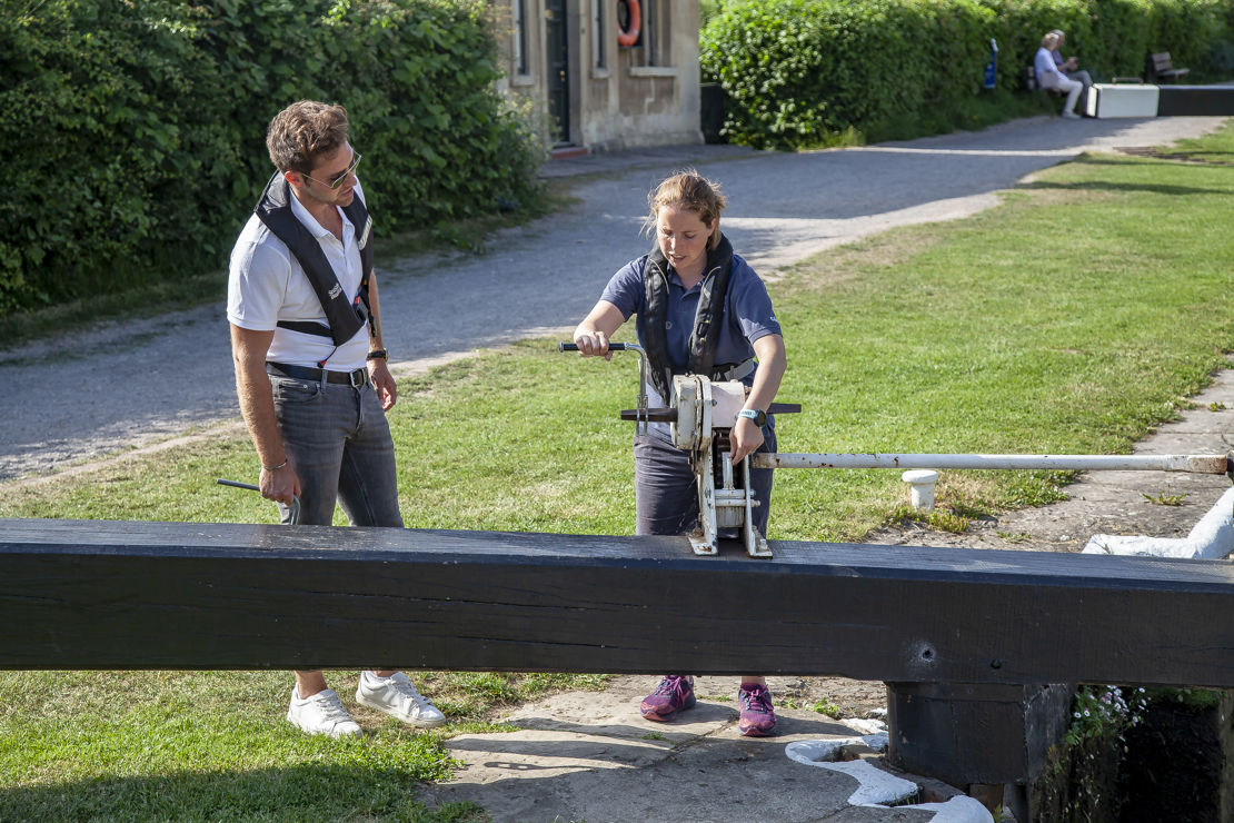 Trainer showing trainee how to operate canal lock