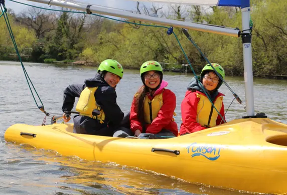 Three children enjoying sailing on the water