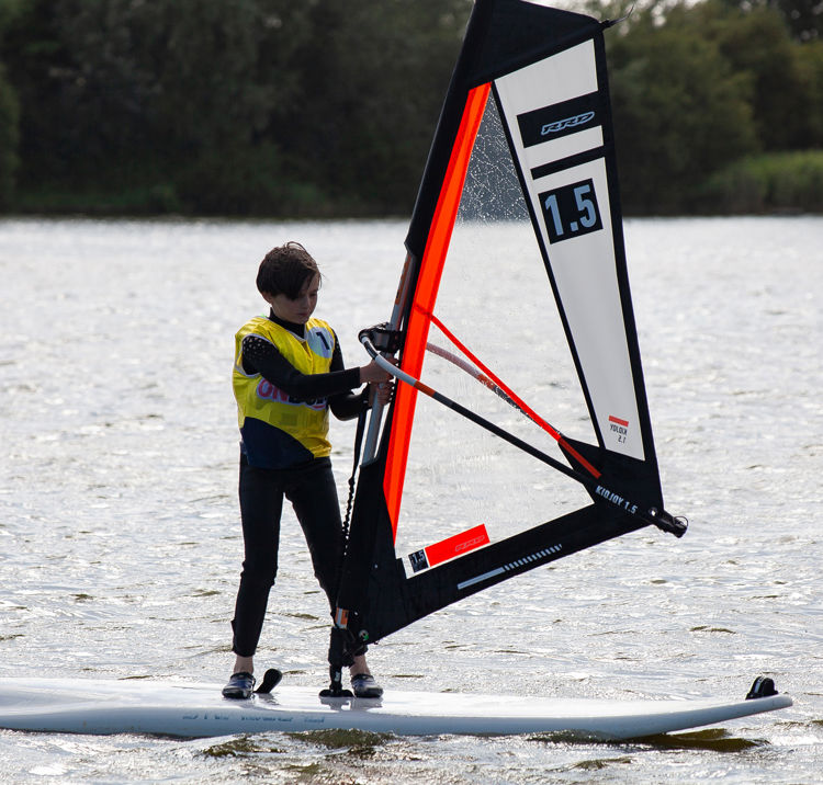 Confident windsurfer standing on board