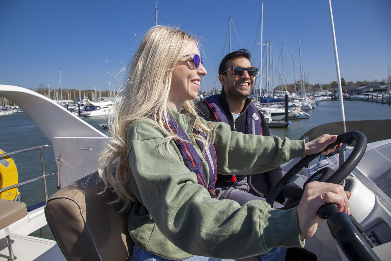 Couple looking out at the horizon at the helm of their powerboat