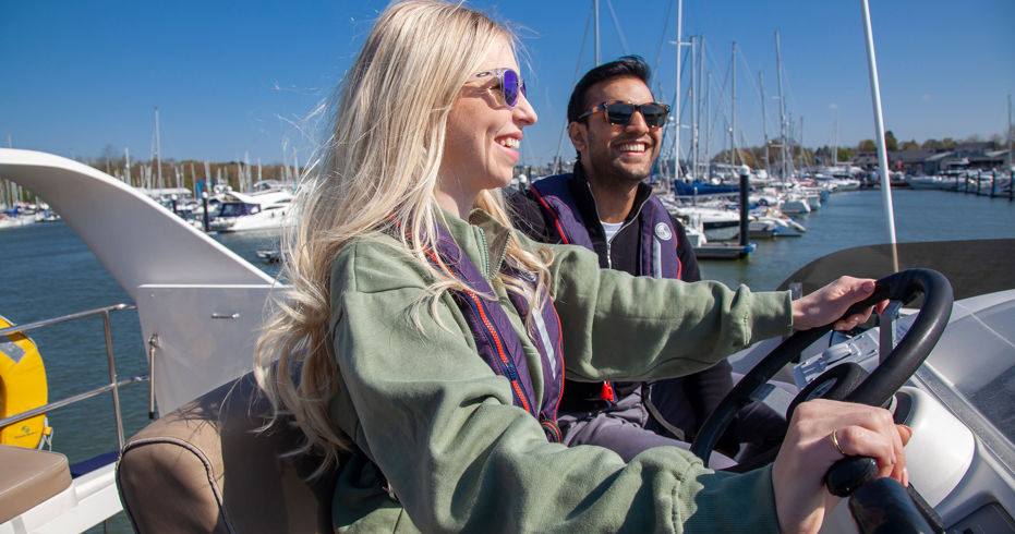 Couple looking out at the horizon at the helm of their powerboat