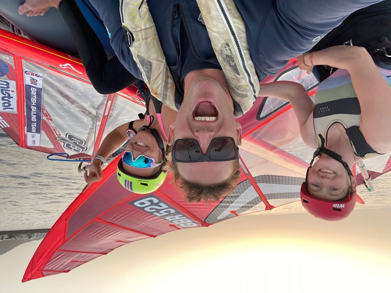 Three wingsurfers smiling at the camera 