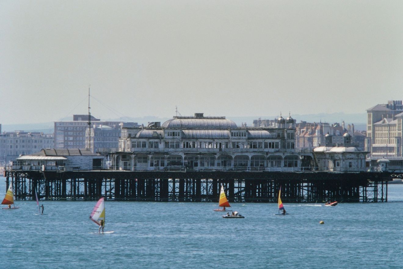 Wide shot of windsurfers in front of pier 