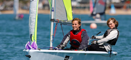 Two children smiling from their dinghy