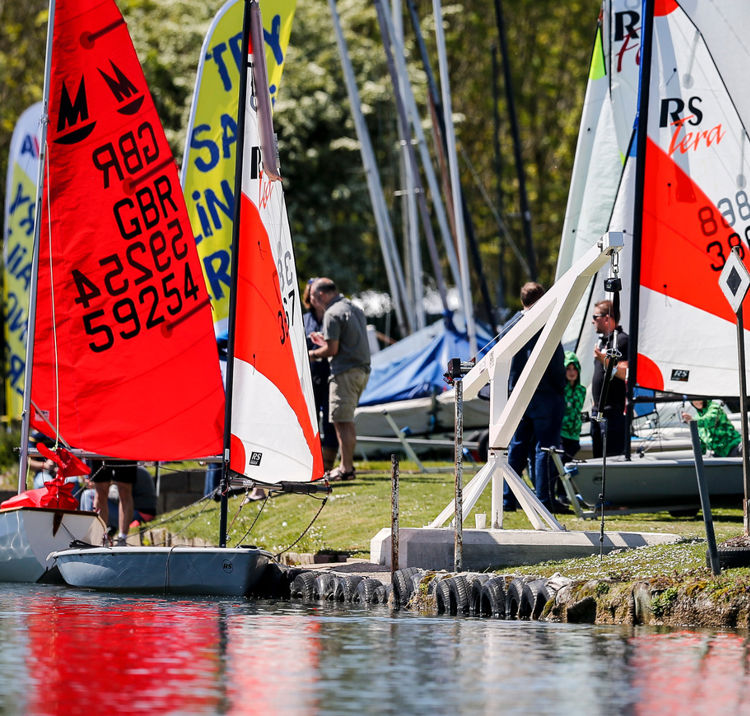 Boats Tied Up On The Side Of A Lake