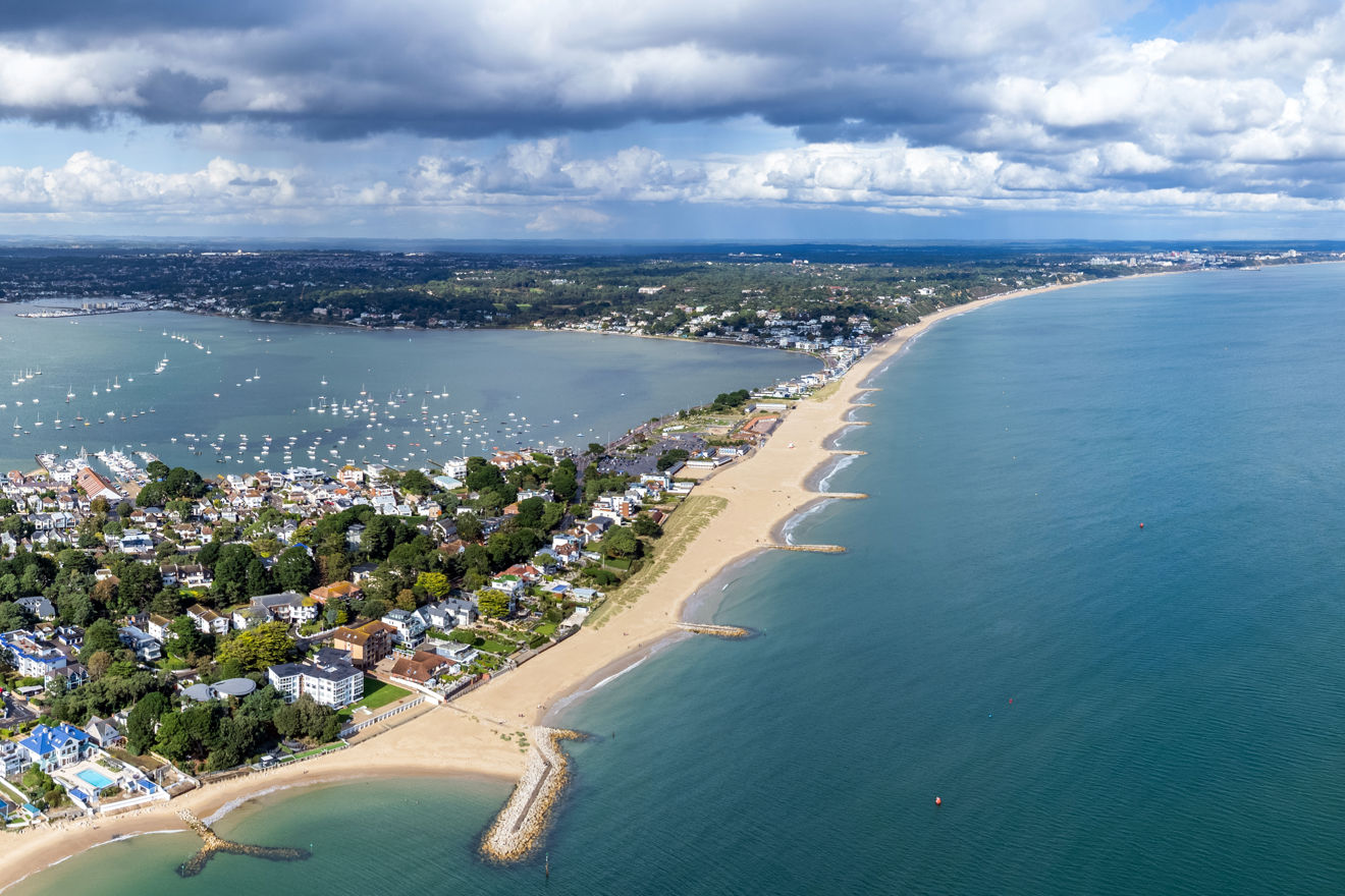 Birdseye view of coast with boats moored and sailing