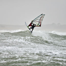 windsurfer travelling through crashing waves