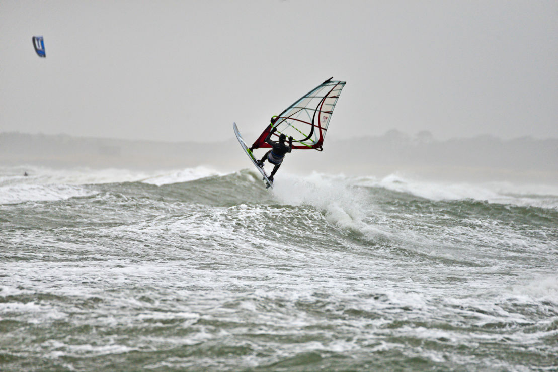 windsurfer travelling through crashing waves