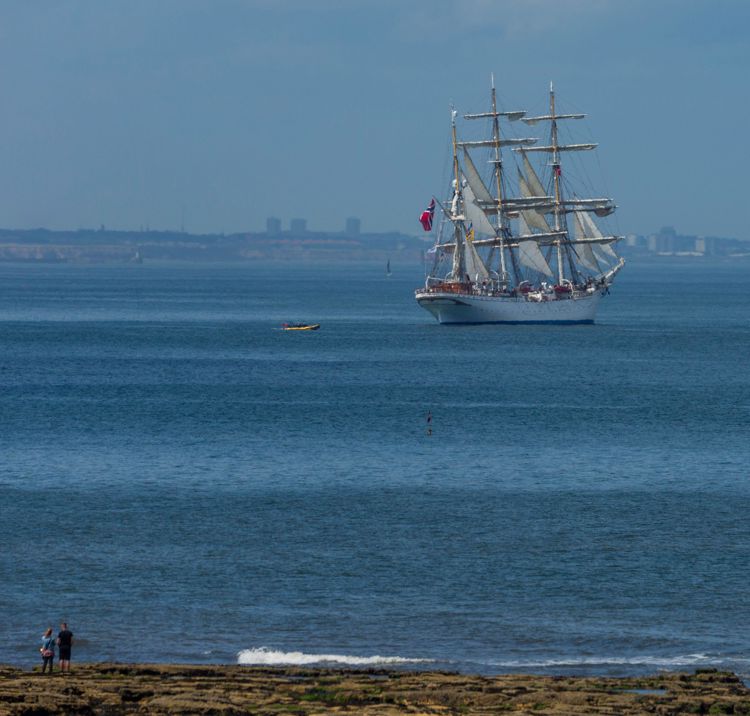 Boat sailing in the distance through blue waters