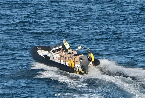 A rigid inflatable dinghy (RIB) being driven out on the open water from Yacht Sail Training School, Brac Island, Croatia