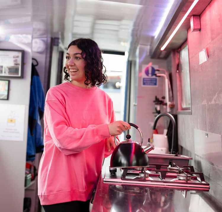 Mid shot of woman using gas appliance on boat