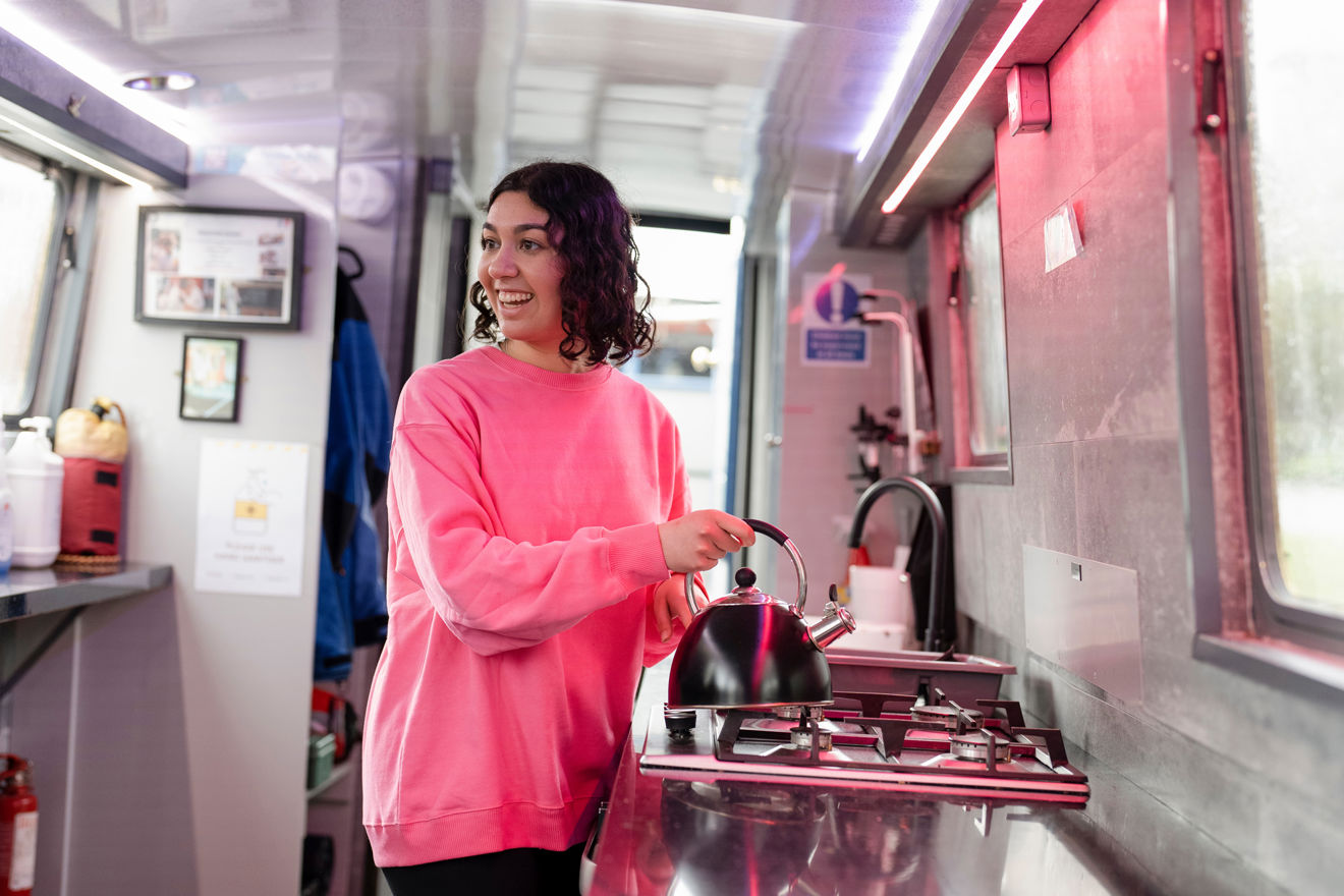 Mid shot of woman using gas appliance on boat