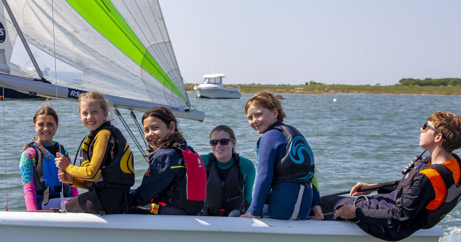 Children smiling at the camera from their dinghy