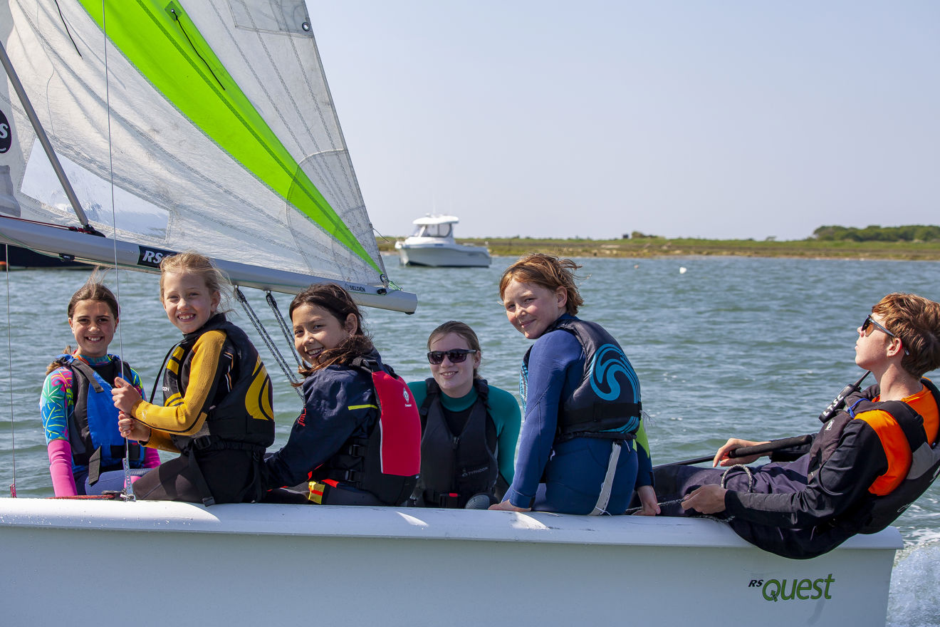 Children smiling at the camera from their dinghy