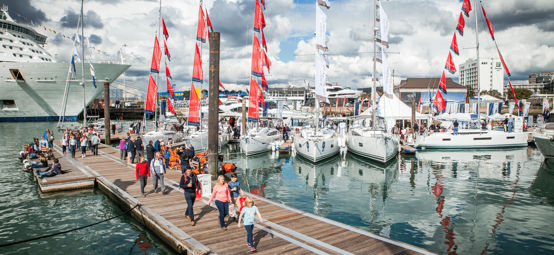 	An image of Visitors exploring and walking down by the boats in sea during the Southampton Boat Show
