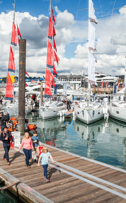 	An image of Visitors exploring and walking down by the boats in sea during the Southampton Boat Show