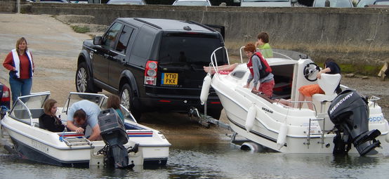 An image of boats being towed by the cars