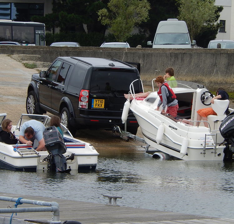 An image of boats being towed by the cars