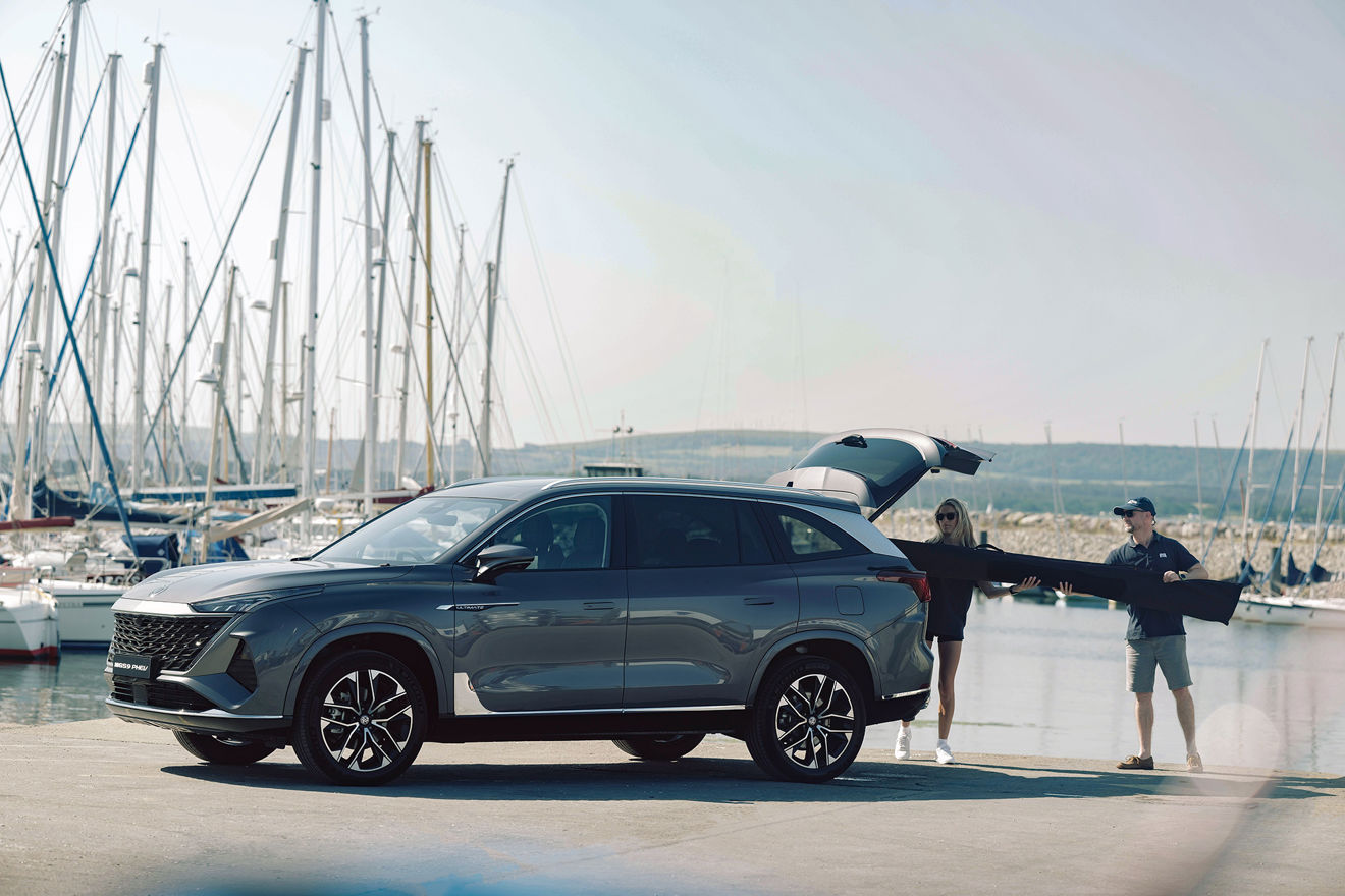 MG S29 Plug-in Hybrid SUV on a slipway at a marina. A couple load an item into the boot.